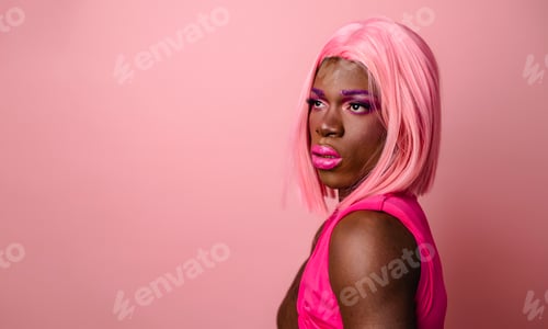 Preview: Smiling confident black drag queen wearing pink outfit looking at empty space