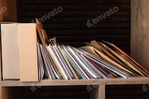Preview: Different paper envelopes and parcels on wooden shelf in post office