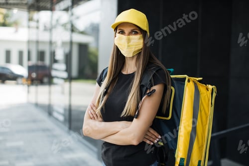 Preview: Food delivery courier woman wearing facial protective mask, working during covid-19 pandemic