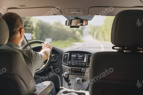 Preview: Young man holding steering wheel while driving car. Road trip adventure
