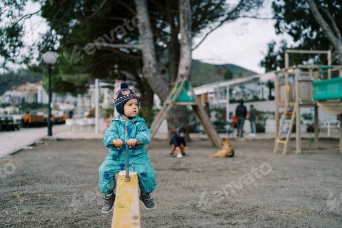 Preview: Little girl sits on a swing-balancer and looks away