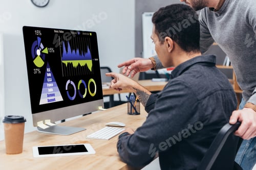 Preview: cropped shot of business colleagues using desktop computer with charts and graphs on screen in