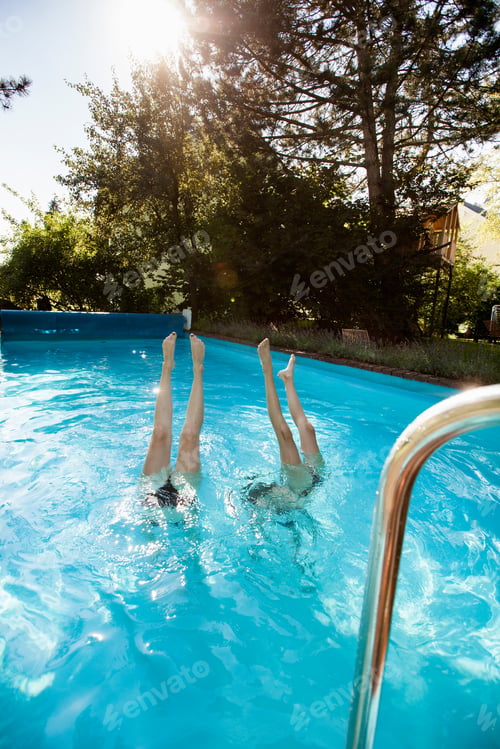 Preview: Two teenage girls diving into swimming pool