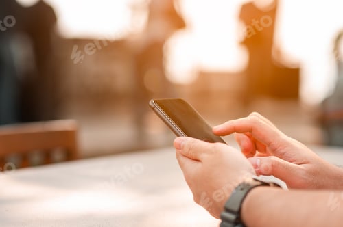 Preview: Close up of a man using mobile smart phone.Man using mobile smart phone outdoor in summer.