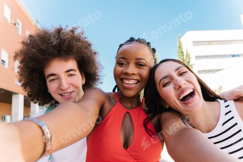Preview: Multicultural happy friends having fun taking group selfie portrait on city street.