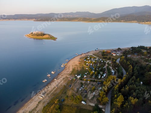 Preview: Aerial view of a campers van parked on a beach, mountain range landscape