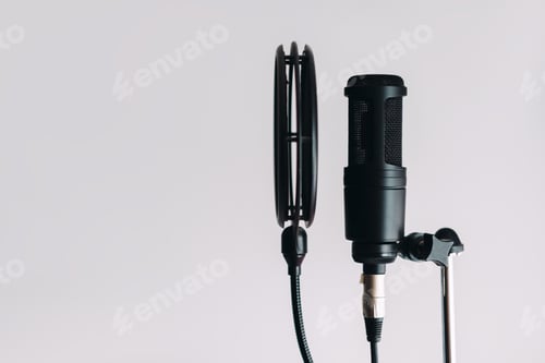 Preview: Black condenser microphone on stand with pop filter isolated on gray background with copy space.