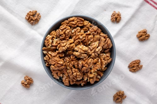 Preview: Raw Organic Walnuts in a Bowl, top view. Flat lay, overhead, from above.