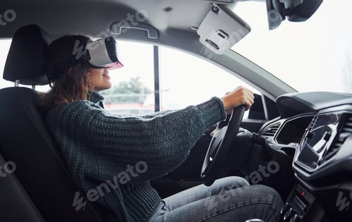 Preview: Side view of woman in virtual reality glasses that sitting inside of modern car