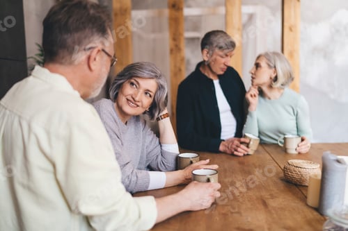 Preview: Aged couples sitting at table apart talking to partners