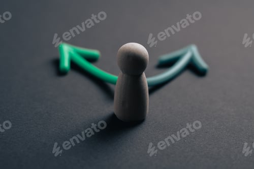 Preview: Wooden figure at a crossroads with two diverging arrows for strategic business decision making