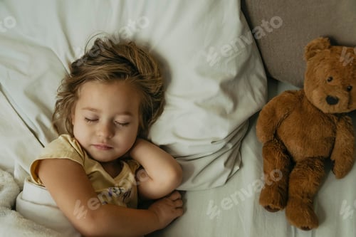 Preview: Portrait of cute little girl sleeping in bed with toy bear