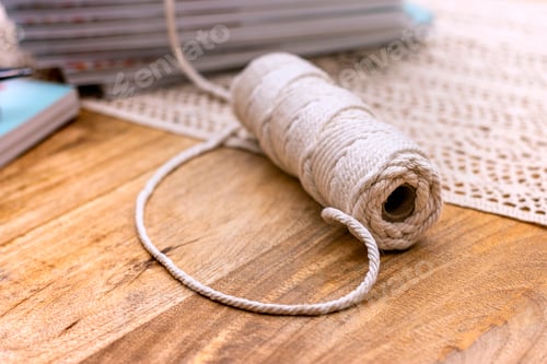 Preview: Macrame. Handmade macrame braiding and cotton threads on wood background. Macrame mandala workshop