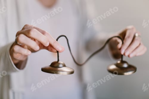 Preview: Close-up shot of a woman's hands holding Tibetan meditation bells.