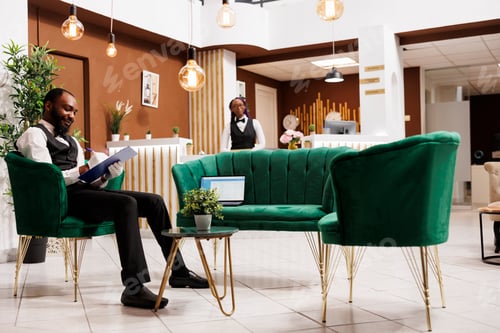 Preview: Smiling guy bellboy at hotel lobby