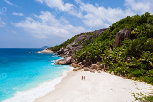 Preview: men and woman walking at a tropical beach, Drone view from above Seychelles Cocos Island