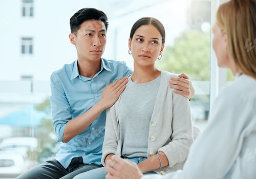 Preview: Shot of a mature doctor comforting a young couple while delivering some bad news at work