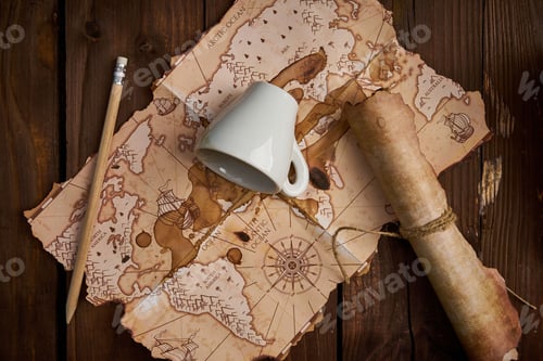 Preview: Aged parchment scroll with an old map and a spilled coffee cup on a wooden table.