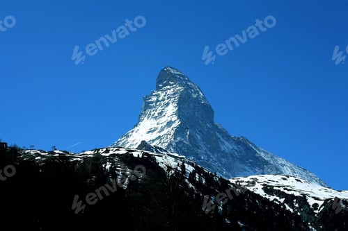 Preview: Iconic Matterhorn mountain peak under a clear blue sky, showcasing the beauty of the Swiss Alps.