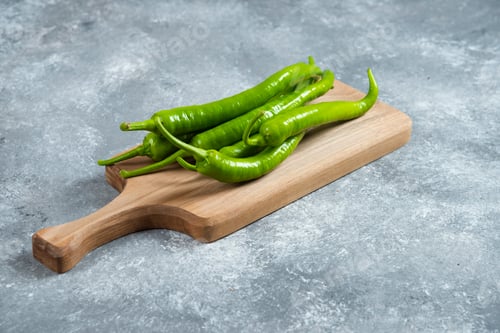 Preview: Green chili peppers on wooden board