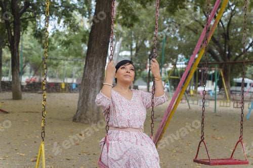 Preview: Woman swinging in an outdoor park.