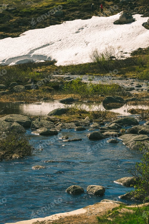 Preview: Hiker Exploring Serene Mountain Stream Landscape in Spring.