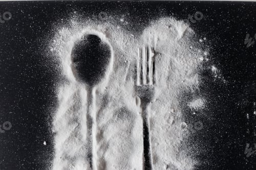 Preview: White sugar on black background with silhouette of spoon and fork