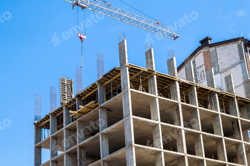 Preview: Modern building under construction against blue sky. Tower crane construction work site