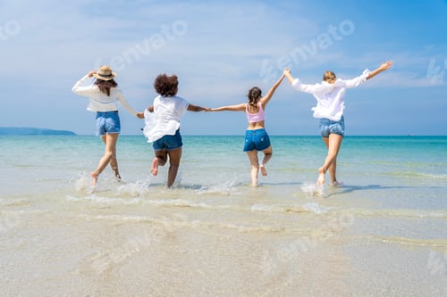 Preview: group of girls of different ethnicities running and having fun together at beach