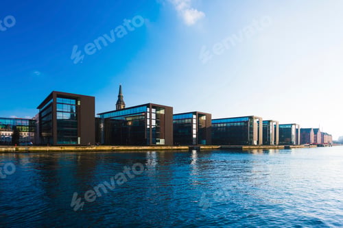 Preview: Modern waterfront buildings under a clear blue sky