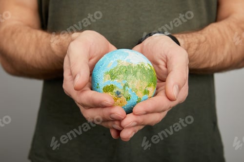 Preview: man holding planet model on grey background, earth day concept