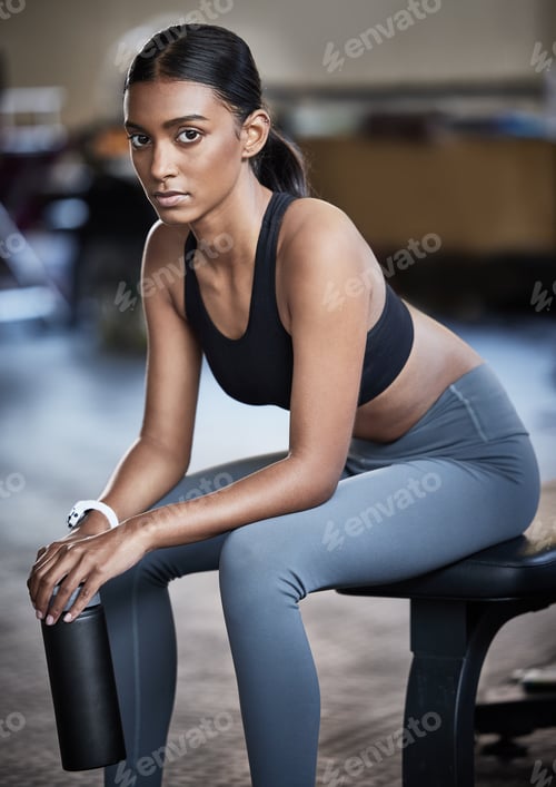 Preview: Portrait of a sporty young woman taking a break while exercising in a gym