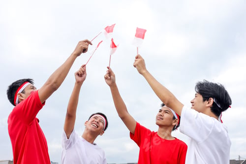 Preview: Happy Young Indonesian Men With Headbands Raise Small Indonesian Flags In The Air For Celebrating