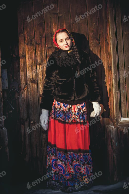 Preview: Russian girl in the winter in the village near the old house. Beautiful woman in winter scarf on