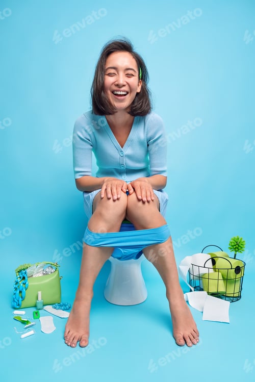 Preview: Positive brunette Asian woman giggles happily poses on toilet bowl reveals herself being in good moo