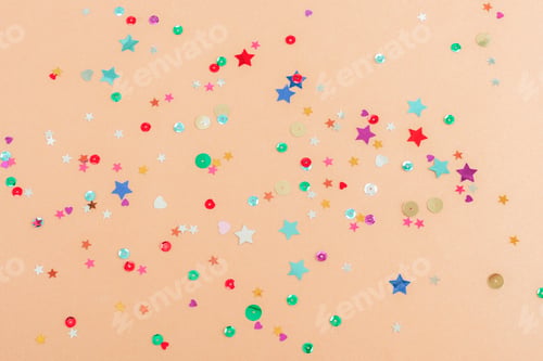 Preview: Various shiny colorful confetti on beige background. Christmas, New Year, Birthday
