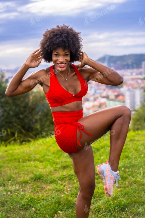 Preview: Fitness with a young black girl with afro hair, showing muscle, exercising in the field