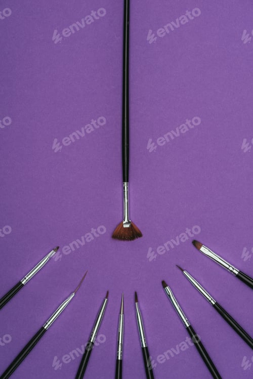 Preview: top view of manicure brushes isolated on purple