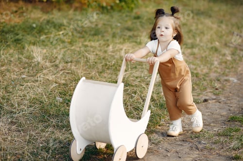 Preview: Cute little girl playing in a park with white carriage