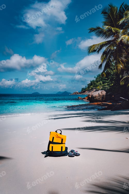 Preview: Traveler yellow backpack and flip flops on the sandy tropical beach on summer holidays trip, travel