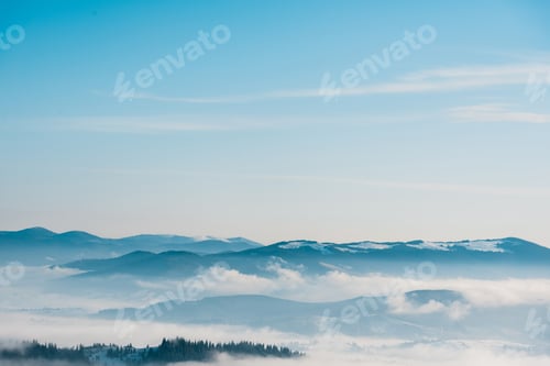 Vorschau: malerischer Blick auf verschneite Berge mit Pinien in weißen, flauschigen Wolken