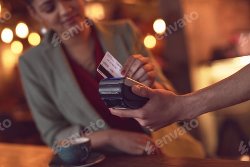 Preview: Simply swipe it. Closeup shot of a young woman swiping her credit card to make a payment in a cafe.