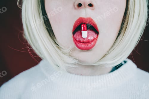Preview: Conceptual image about drug addict with a pill in a young woman tongue