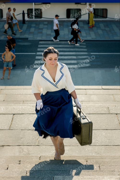 Preview: A girl stands with a suitcase in her hands on the embankment of the river station, port.