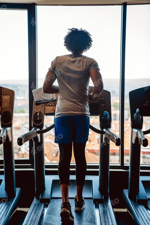Preview: Happy fit man at the sport gym doing exercise on the treadmill