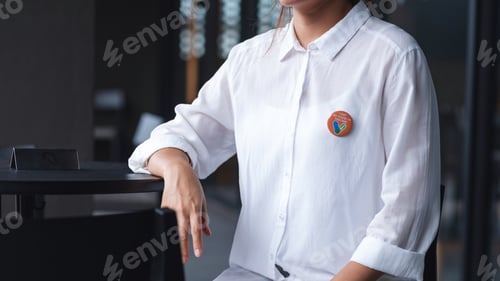 Preview: Closeup image of a woman with Covid-19 vaccinated sign brooch on shirt