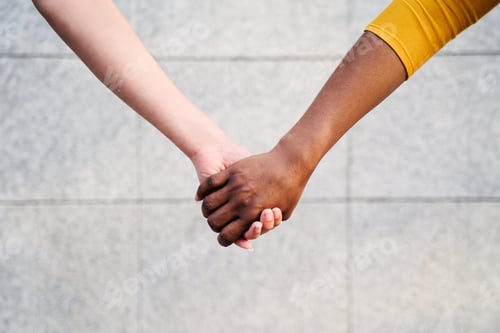 Preview: Close up of two unrecognizable multiracial women holding hands. Diverse young lesbian couple.
