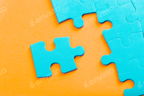 Preview: Puzzle pieces scattered on orange background featuring vibrant blue color