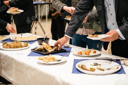 Preview: People in suits serve themselves at the buffet and eat delicious food at a business event