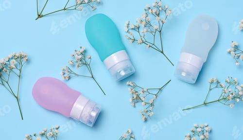 Preview: Plastic tubes for cosmetics and sprigs of white gypsophila flowers, top view
